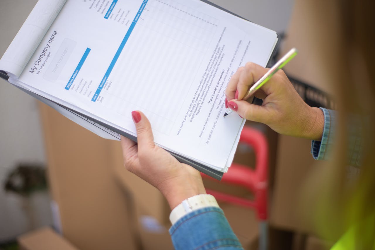 Close-up of womans hand signing a document on a clipboard. Ideal for business and legal themes.